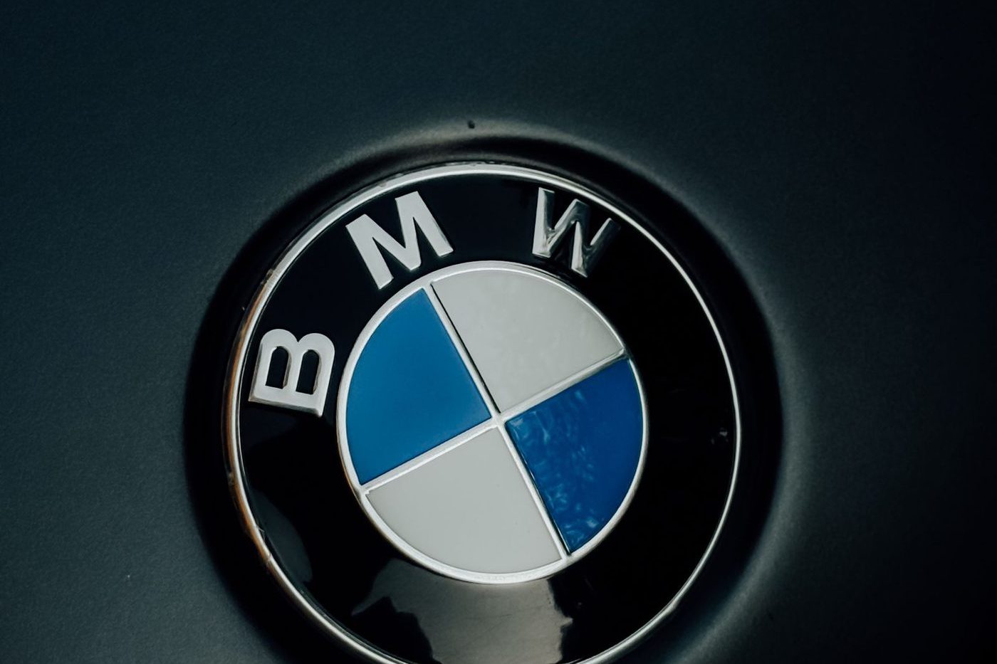 BMW roundel with blue and white quarters on a dark car bonnet