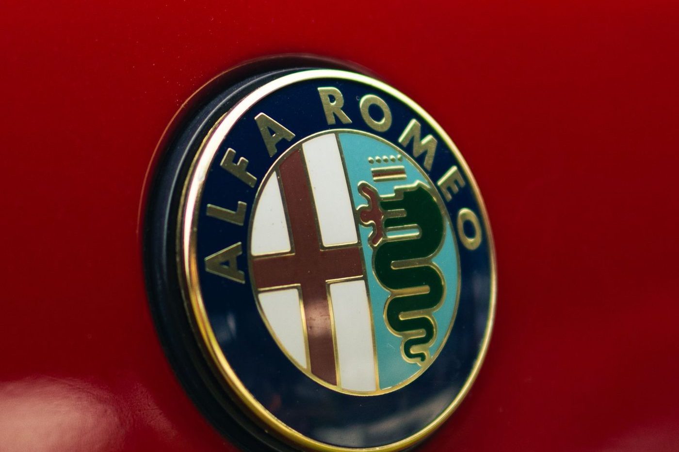 Alfa Romeo badge with the red cross and the Visconti serpent on a red car