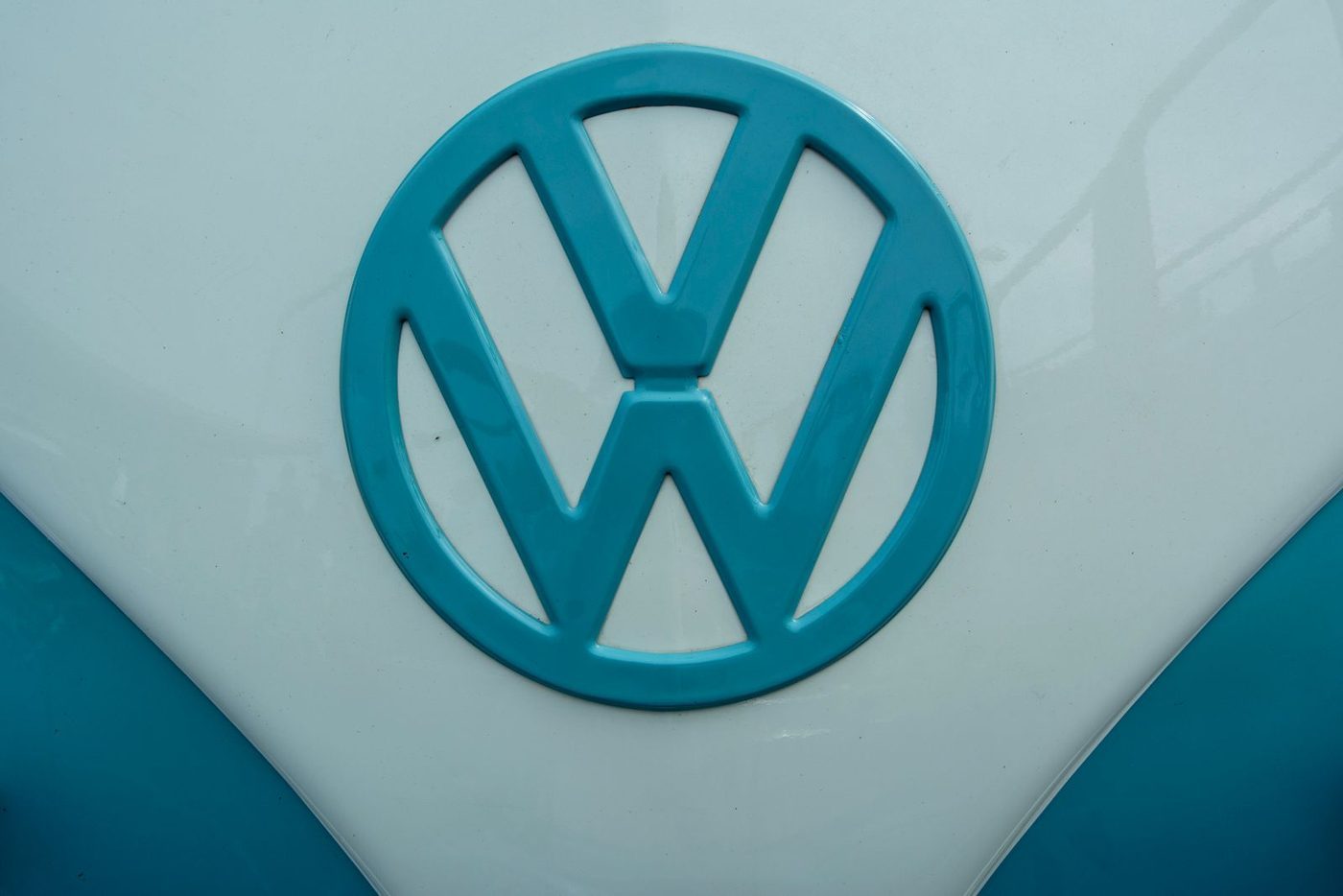 Close-up of a large Volkswagen badge on a light blue van